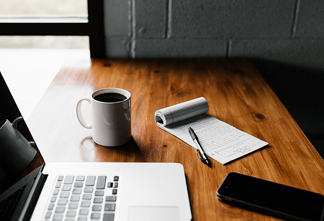 A workspace with a laptop and notebook